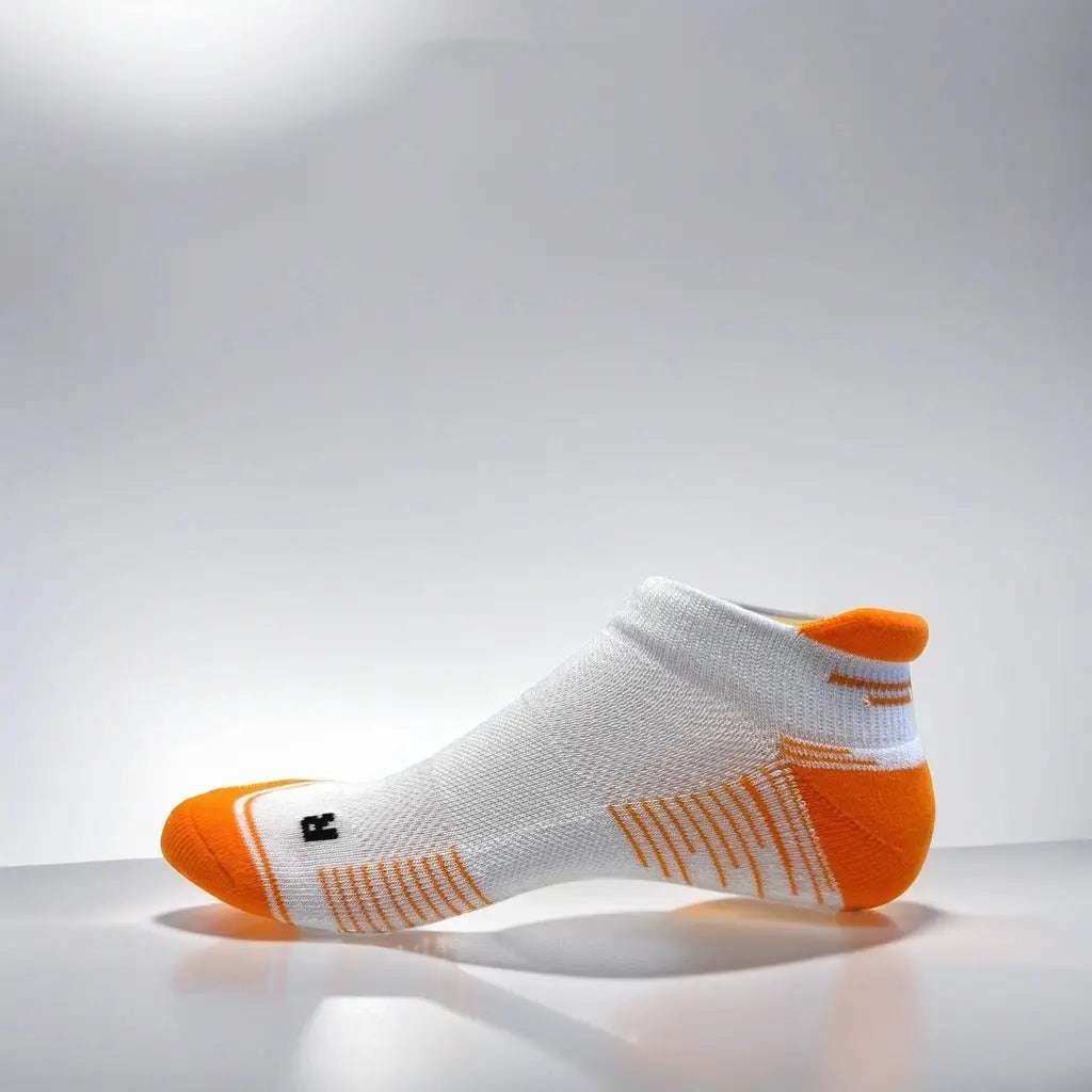 Low cut white and orange running socks with arch support and ventilation.